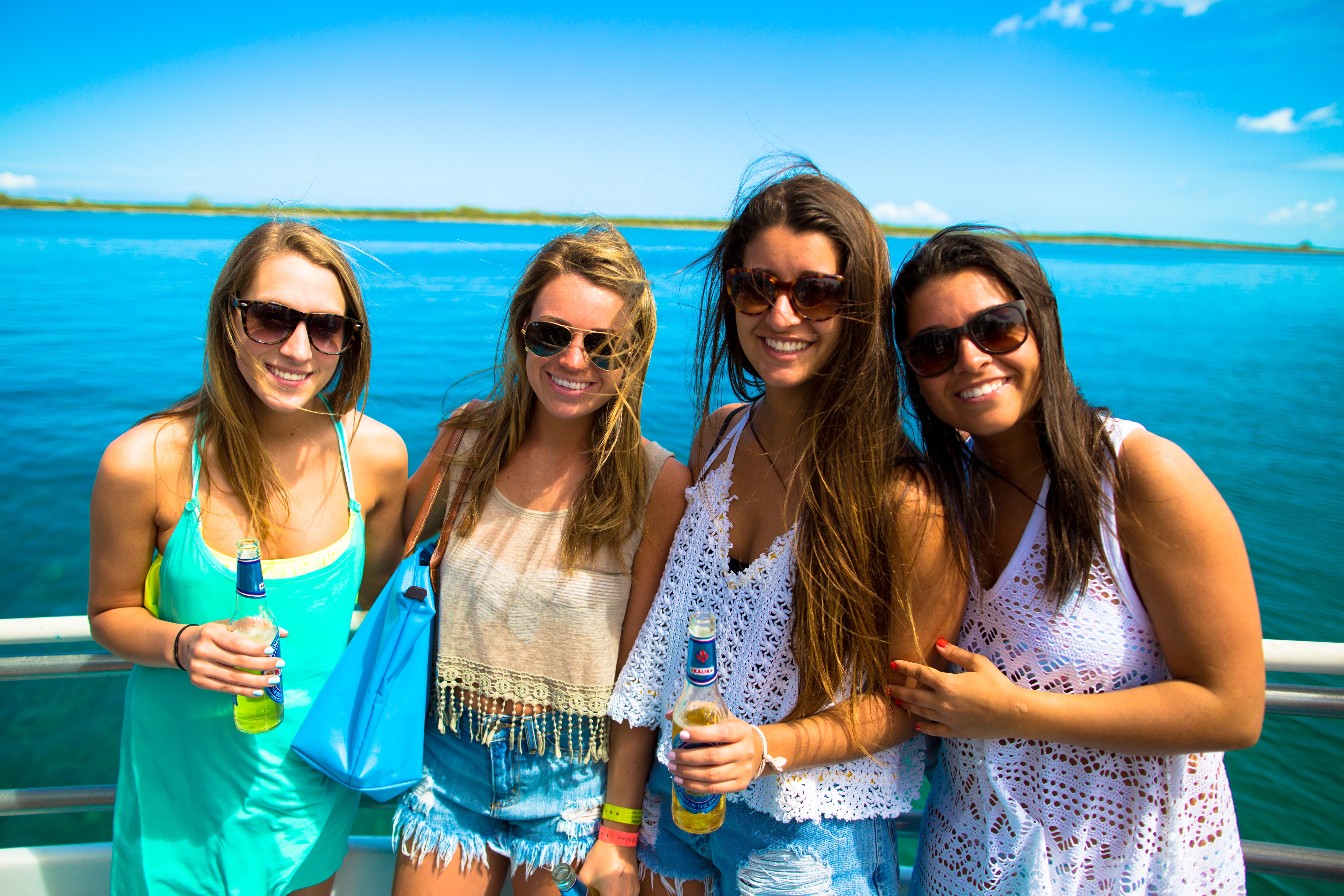 group of girls posing for a picture on student city Bahamas party cruise with the ocean in the background