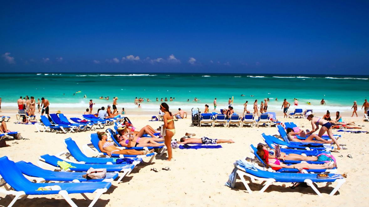 large group of people relaxing on lounge chairs on the beach in Punta Cana