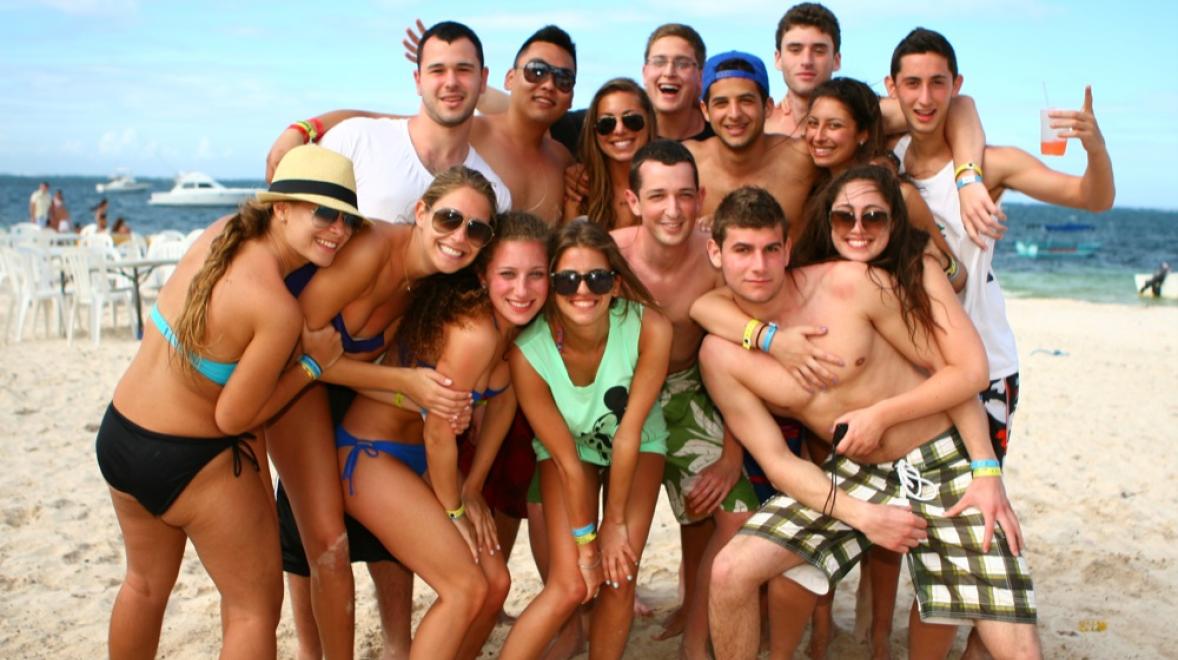 a group of spring breakers posing for a photo on the beach in Punta Cana